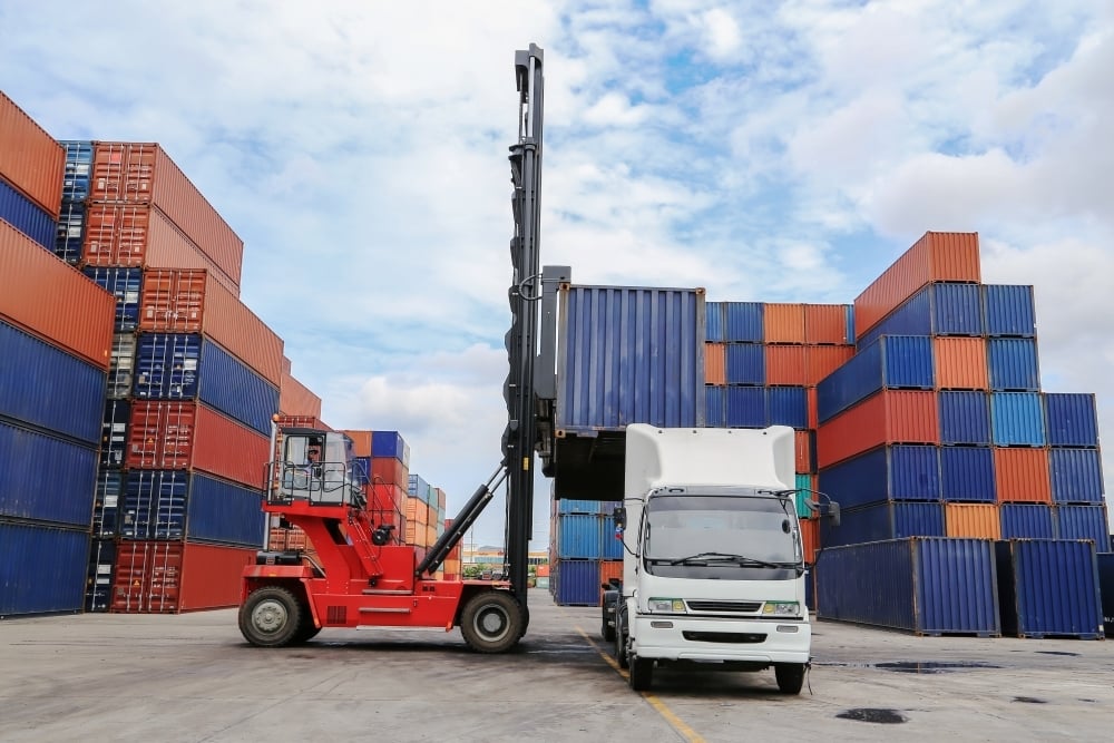 a-red-container-handler-loads-a-shipping-container-2026-01-09-11-51-48-utc